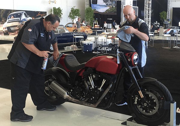 Harry Sandwith and Bob Wiener detailing a red ARCH motorcycle owned by Keanu Reeves at Monterey Car Week